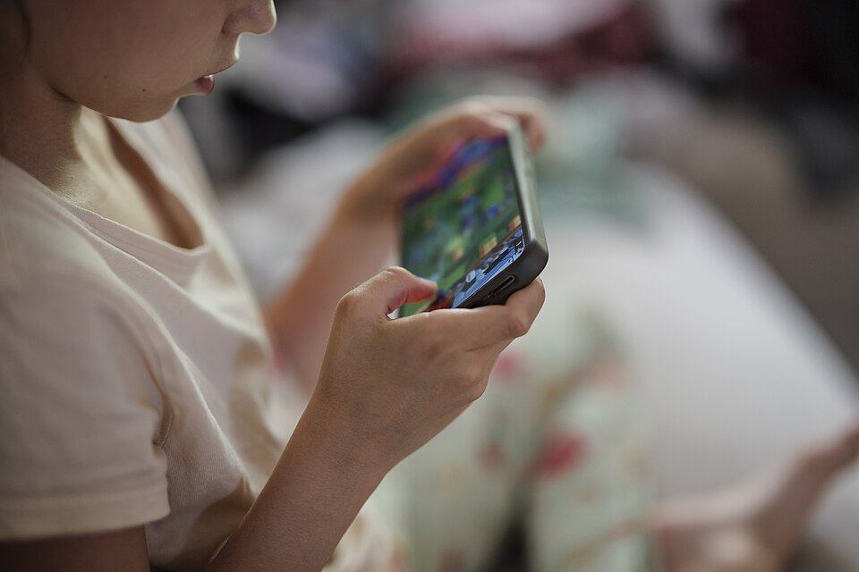 A child holding a smartphone and playing a game