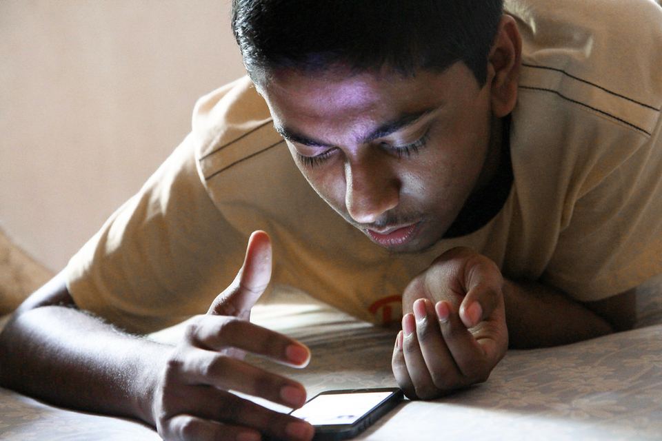 A teenager looking at a smartphone