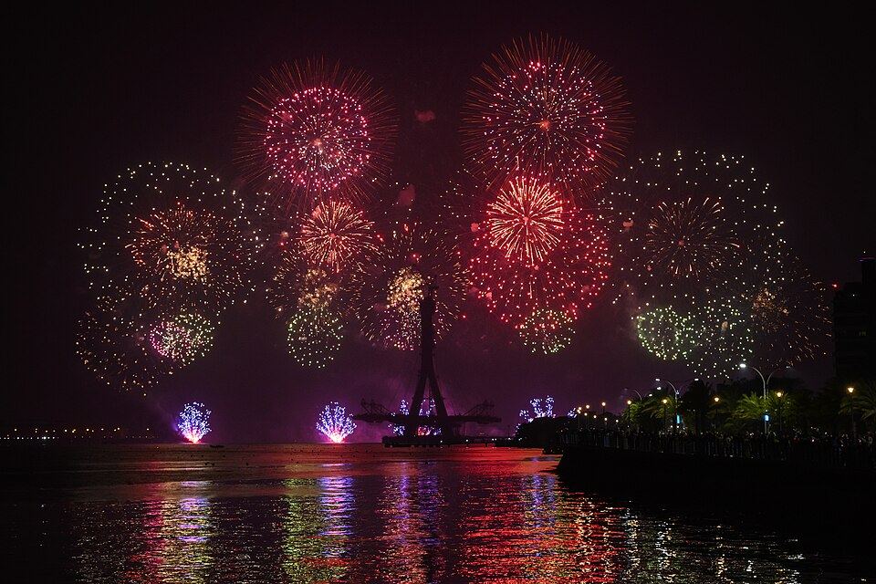 New Year fireworks bursting over a waterfront at night