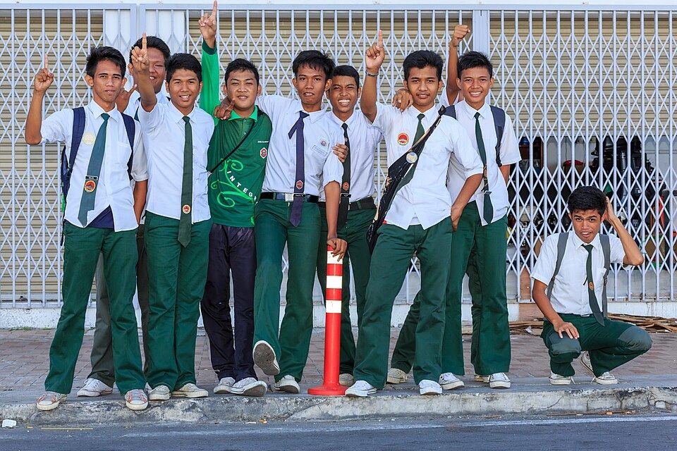 Schoolboys in white shirts and dark trousers walking together